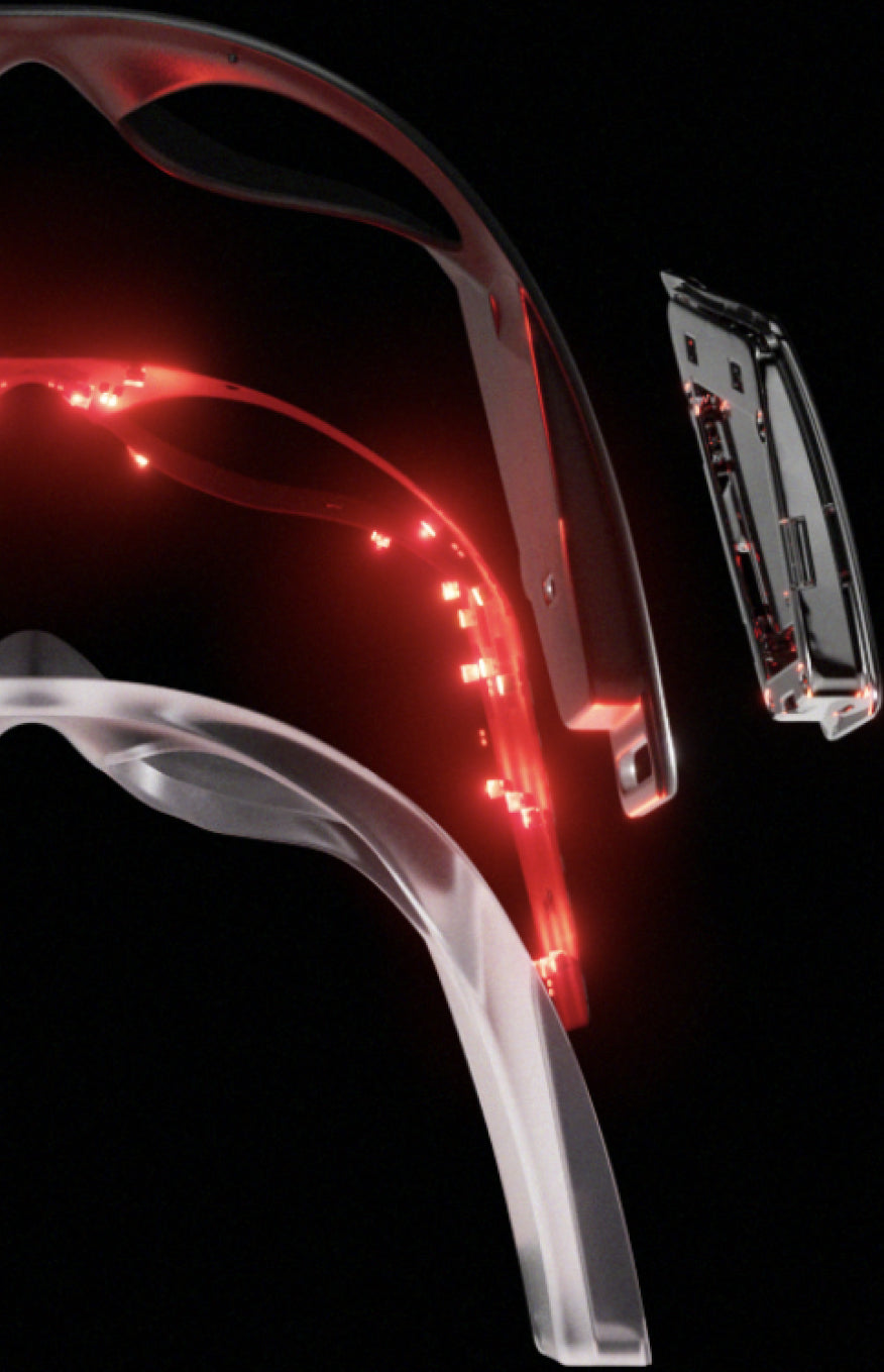 Wireless smart glasses frame parts with glowing red LED circuit elements and sleek design against black background.