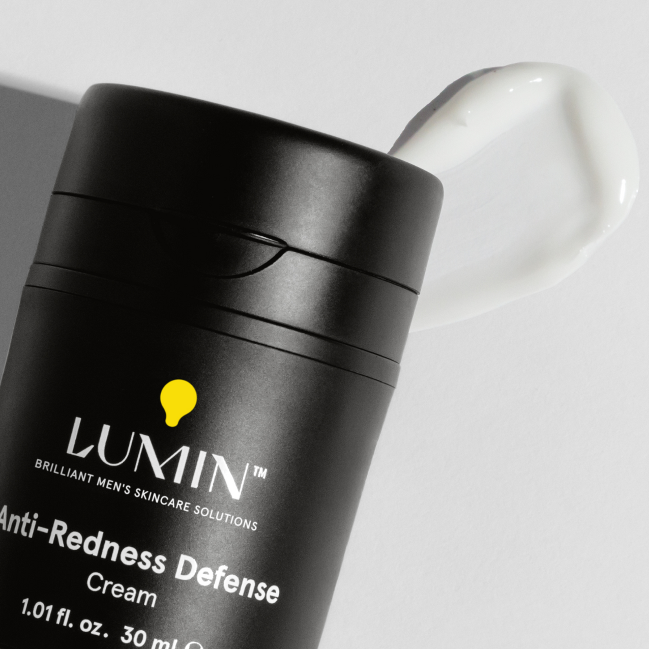 Lumin Anti-Redness Defense cream for men with smooth white moisturizer swatch on white background
