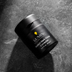 Lumin men's Instant Dark Circle Corrector skincare jar on textured dark stone background, 0.67 fl oz packaging.