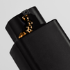 Black electronic vape device with glossy gold liquid dripping near the mouthpiece on a plain background.