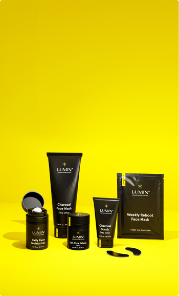 Lumin men's skincare set with Daily Face Moisturizer, Charcoal Face Wash, Dark Circle Defense Cream, Charcoal Scrub, Weekly Reboot Face Mask, and eye patches.